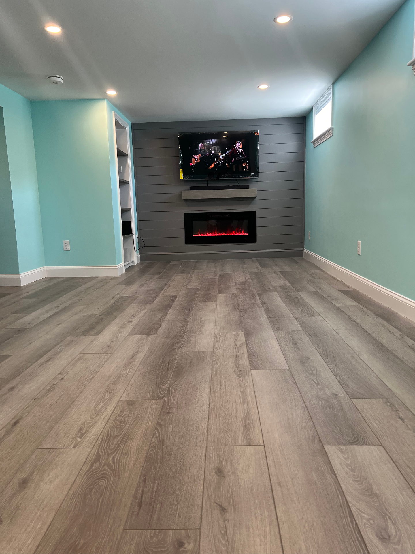 Finished basement with fireplace wall by Cane Hill Wood Works in Weston MA.